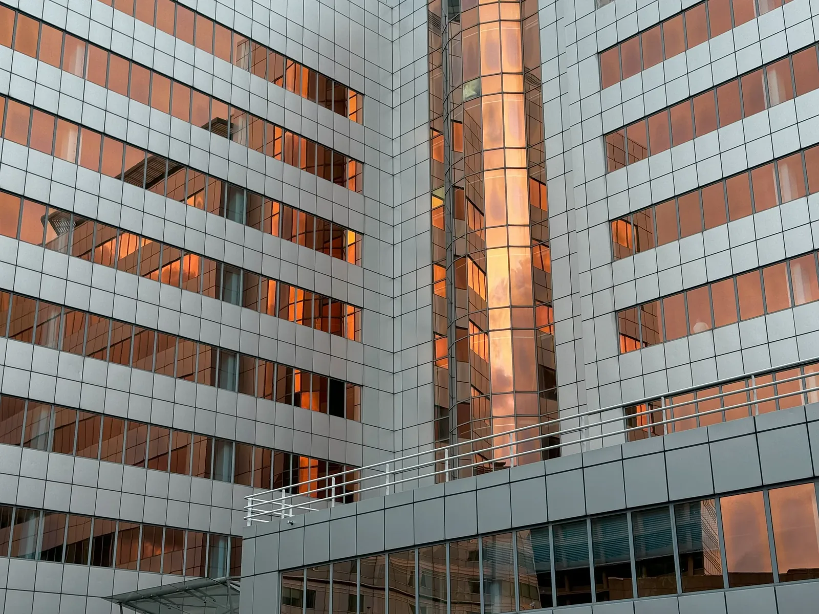 Moderne Glasfassade mit orangefarbenen Lichtreflexionen